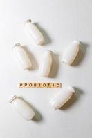 Small bottles with probiotics and prebiotics dairy drink on white background. Production with biologically active additives. Fermentation and diet healthy food. Bio yogurt with useful microorganisms. photo