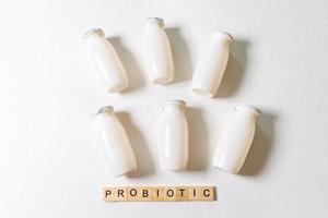 Small bottles with probiotics and prebiotics dairy drink on white background. Production with biologically active additives. Fermentation and diet healthy food. Bio yogurt with useful microorganisms. photo