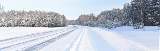 panorama invierno camino cubierto de nieve y bosque foto
