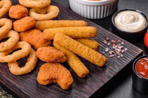 Snack platter - cheese sticks, chicken nugget, onion rings mix of snacks and sauces photo