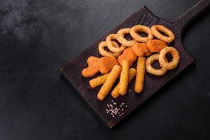 Snack platter - cheese sticks, chicken nugget, onion rings mix of snacks and sauces photo