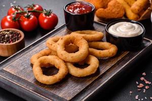 Homemade crunchy fried onion rings with tomato sauce