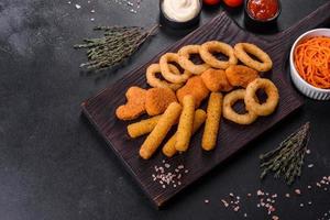 Snack platter - cheese sticks, chicken nugget, onion rings mix of snacks and sauces photo