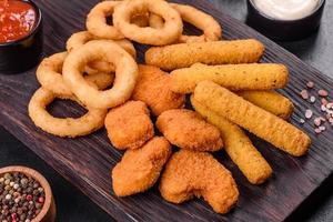 Snack platter - cheese sticks, chicken nugget, onion rings mix of snacks and sauces photo