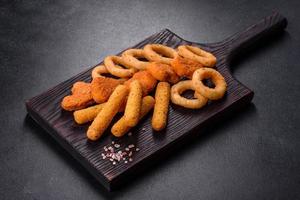 Snack platter - cheese sticks, chicken nugget, onion rings mix of snacks and sauces photo