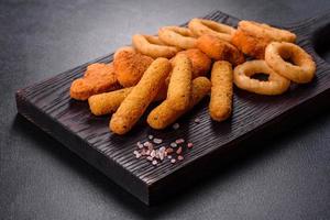 Snack platter - cheese sticks, chicken nugget, onion rings mix of snacks and sauces photo