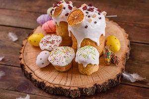 Festive cakes with white glaze, nuts and raisins on the festive table photo