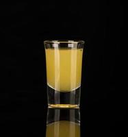 shot glass with alcohol on a dark background photo