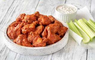 Bowl of buffalo wings with blue cheese dip photo