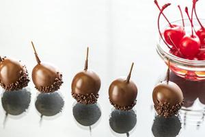 Chocolate and cocktail cherries on the glass photo