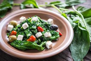 Spinach with cheese, olives and pepper drops photo