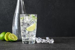 vaso de agua con gas con cubitos de hielo y rodaja de limón