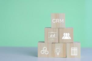 Wooden cubes with CRM  Customer relationship management automation system software symbol on background and copy space.Business concepts. photo