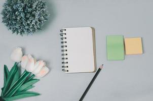 Top view  blank notepad flower and pencil on desk. flat lay with copy space of table office. photo