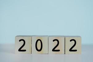 Wooden cubes with new year 2022 symbol on background and copy space. photo