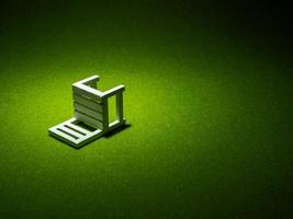 White wooden chair on artificial grass. Light shining down from above in the dark tone low key photo