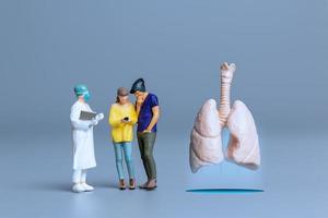 médicos en miniatura estudian y tratan grandes pulmones humanos, concepto del día mundial de la salud foto