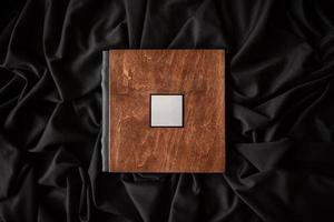 Wooden book with a nameplate on a black fabric background. photo