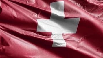 Switzerland textile flag slow waving on the wind loop. Swiss banner smoothly swaying on the breeze. Fabric textile tissue. Full filling background. 20 seconds loop. video