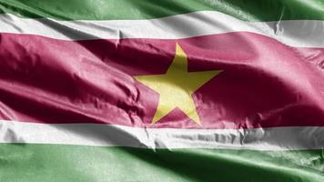 bandeira têxtil do suriname acenando no loop de vento. bandeira surinamesa balançando na brisa. tecido tecido têxtil. fundo de preenchimento completo. loop de 10 segundos. video