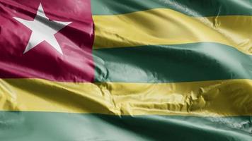 Togo flag waving on the wind loop. Togo banner swaying on the breeze. Full filling background. 10 seconds loop. video
