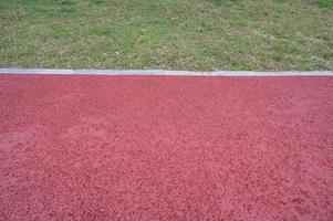 A short runway with green grass and red asphalt photo