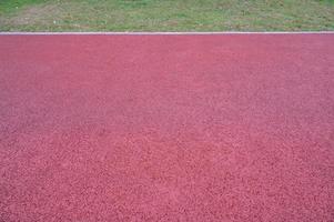 A short runway with green grass and red asphalt photo