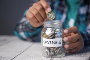 child boy hand hold a saving coins jar photo