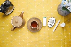 diabetic measurement tools and green tea on a table photo