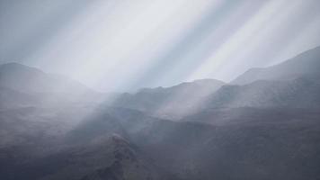 rayos de sol contra el telón de fondo de las montañas video