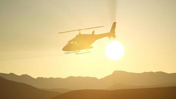 Helicóptero volador en cámara lenta extrema y cielo al atardecer video