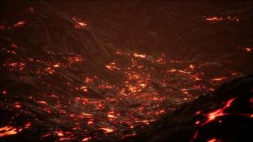 rot-orange leuchtende geschmolzene Lava, die auf ein graues Lavafeld und glänzendes felsiges Land fließt video