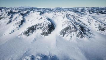 Paisaje aéreo de 8k de montañas nevadas y costas heladas en la Antártida video