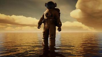 Spaceman in the sea under clouds at sunset video