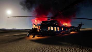 Hélicoptère militaire brûlé dans le désert au coucher du soleil video