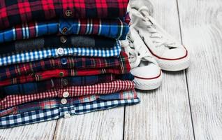 stacks of checkered shirts and sneakers photo