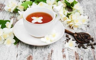Cup of tea with jasmine flowers photo