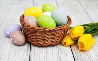 Basket with easter eggs and tulips photo