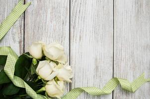 White roses on a wooden table photo