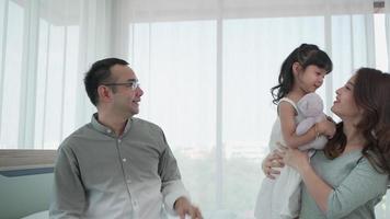 Junge Tochter küsst Vater und schwangere Mutter im Schlafzimmer video
