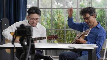 Two Musician Playing Guitar Together and Using Camera to Live in Internet video