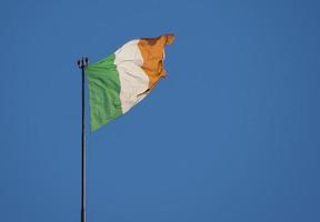 Bandera irlandesa de Irlanda sobre el cielo azul foto