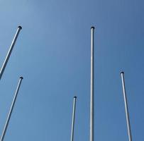 Flagpoles over blue sky photo