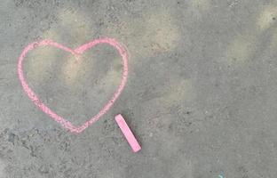 pink heart drawn with chalk on the asphalt. love confession. banner place for text, valentine, children creativity copy space, summer photo