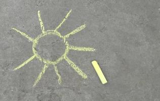 the sun is drawn with chalk on the asphalt. summer. banner place for text, children creativity photo