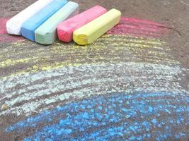 el arco iris se dibuja con tiza en el asfalto. fondo de verano coloreado. dibujo infantil, símbolo lgbt foto