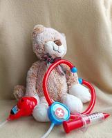 juguetes estetoscopio, jeringa, gato. juego de niños en el hospital. inyección, tratamiento, médico, vacuna. foto