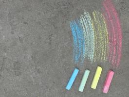 el arco iris se dibuja con tiza en el asfalto. fondo de verano coloreado. niños dibujando, espacio de copia de símbolo lgbt, lugar para texto foto