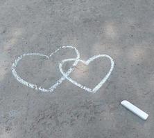 corazón de pareja dibujado con tiza en el asfalto. confesión de amor. banner san valentín, niños creatividad verano foto