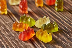 Multicolored bears gummy candy on wooden vintage background. Jelly candies of different colors photo